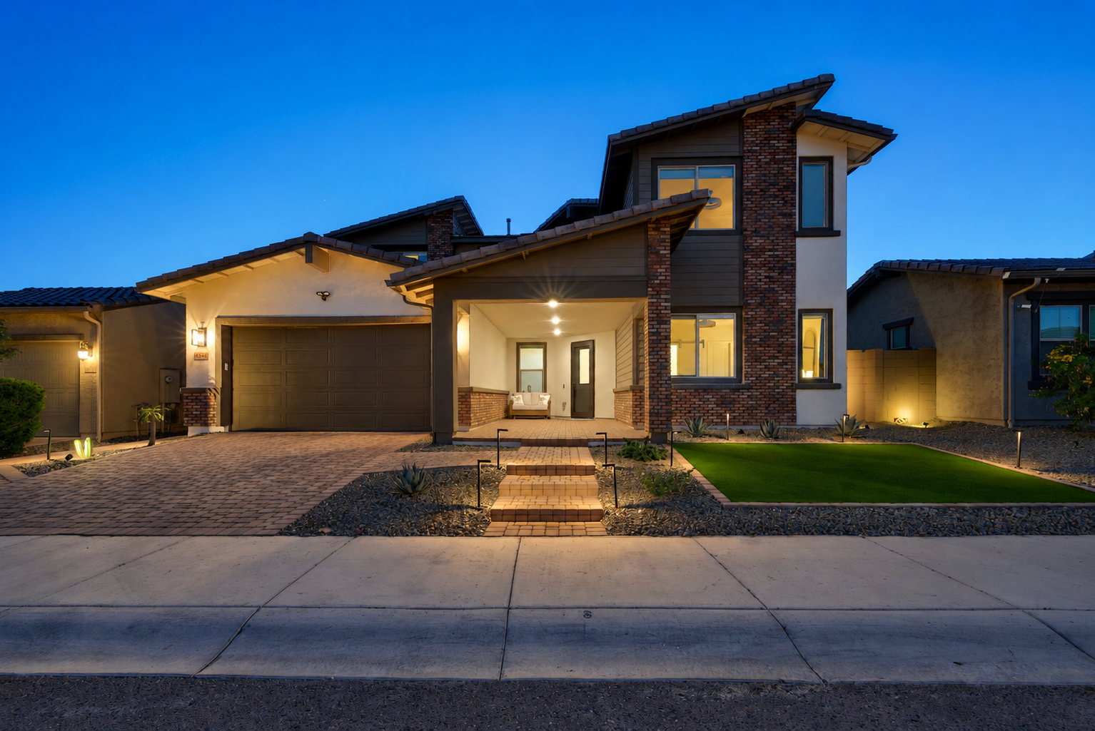 Front exterior of a modern Arizona home at blue hour with warm interior lighting