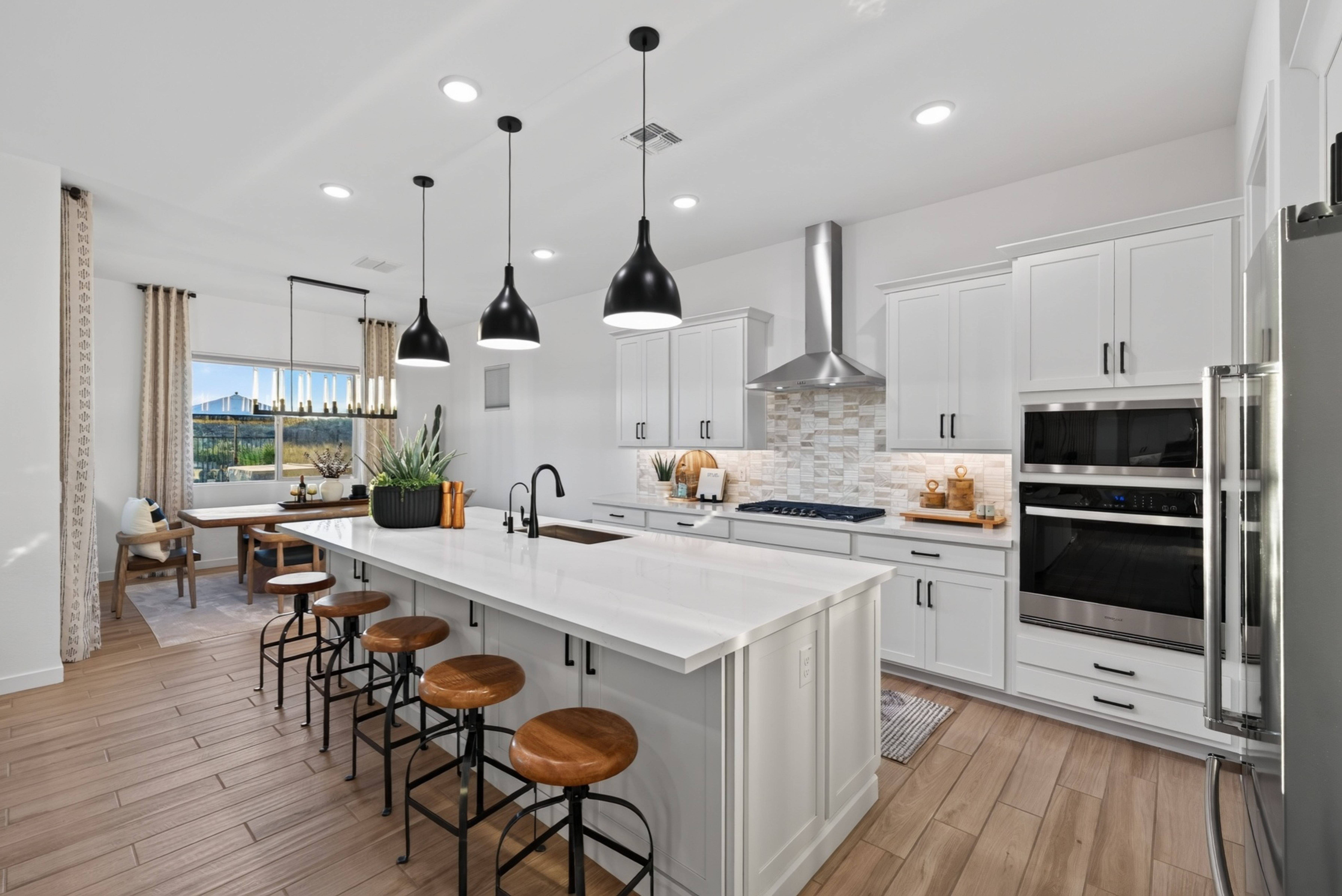 Interior photograph of the property's kitchen with island seating, pendant lighting and a dining nook